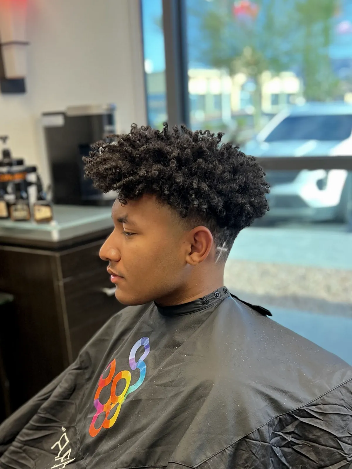 Textured curls with a clean taper by Cuts By Soc